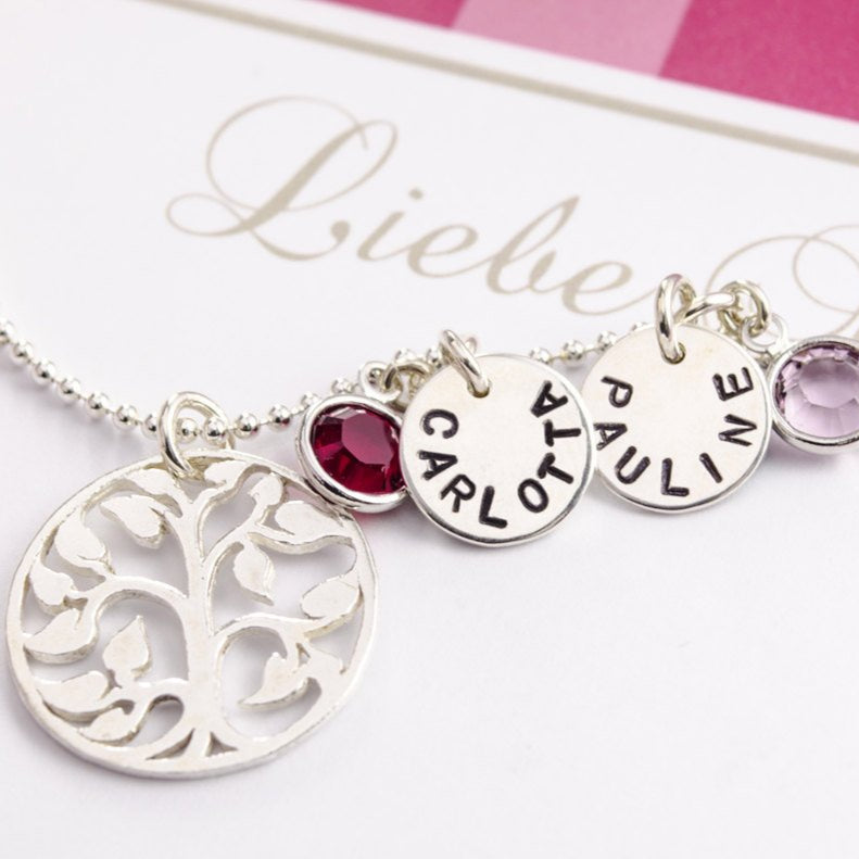 Detailansicht der Lebensbaum Kette 'MY FAMILY' mit zwei handgestempelten Namensplättchen, zwei Monatssteinen und rundem Lebensbaum-Symbol-Anhänger.
