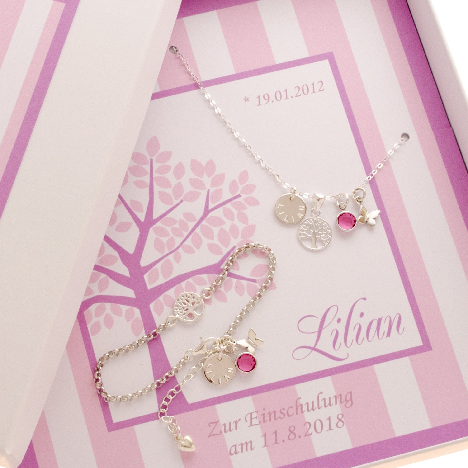 Süßes Schmuck-Set aus Silberkette und Silberarmband mit Namenstaler, rundem Lebensbaum, Geburtsstein und Schmetterling, hier personalisiert für Lilian zur Einschulung.