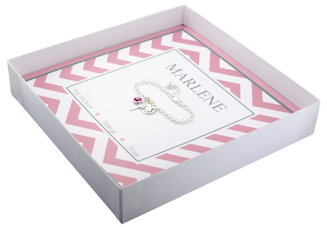 Innenansicht einer Geschenkbox mit Kinderarmband als Geschenk zur Geburt. Die Box ist mit Namen und Geburtsdaten personalisiert.