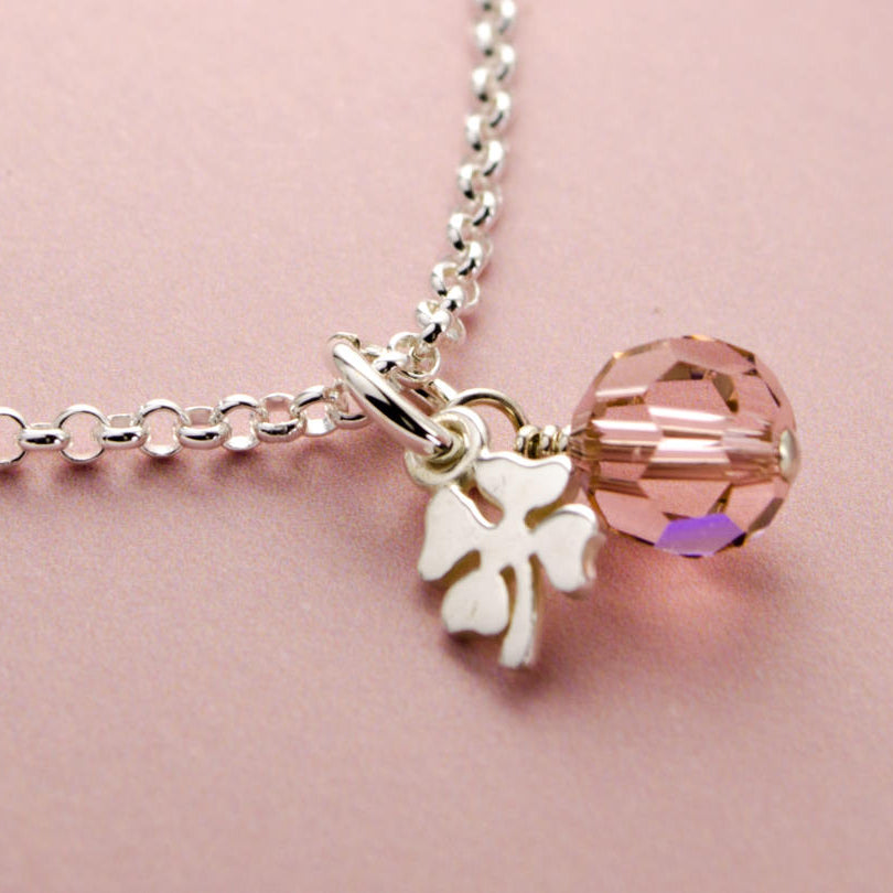 Detailaufnahme der Glücksbringer-Kette mit Kleeblatt aus 925 Sterlingsilber und rosa Glücksstein.