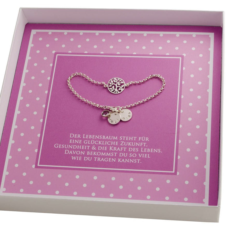 Detailansicht: Handgestempelte Namensplättchen und filigraner Lebensbaum-Anhänger aus Silber