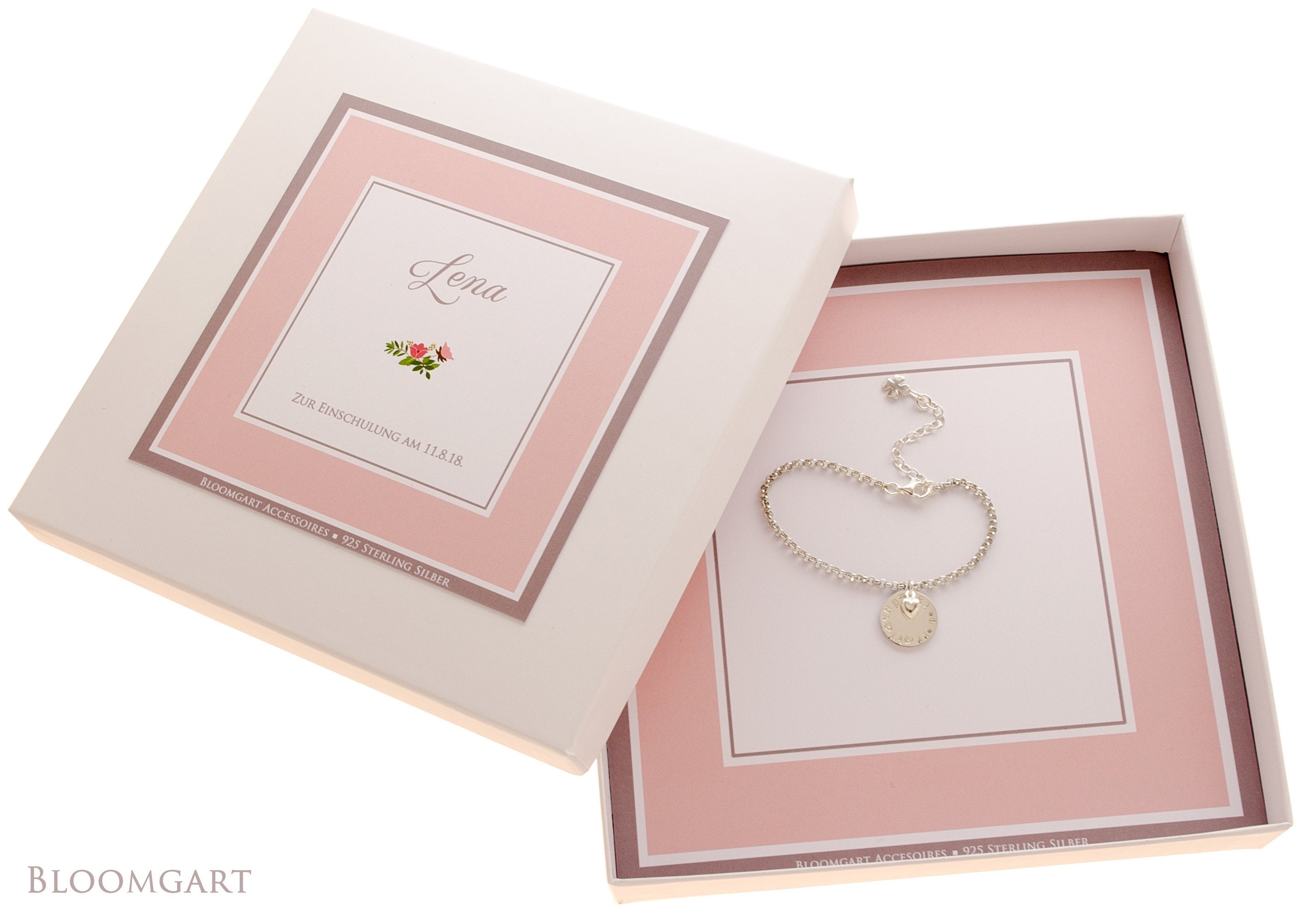 Rosa-weiße Geschenkbox personalisiert für 'Lena' zur Einschulung mit Namensarmband innenliegend.
