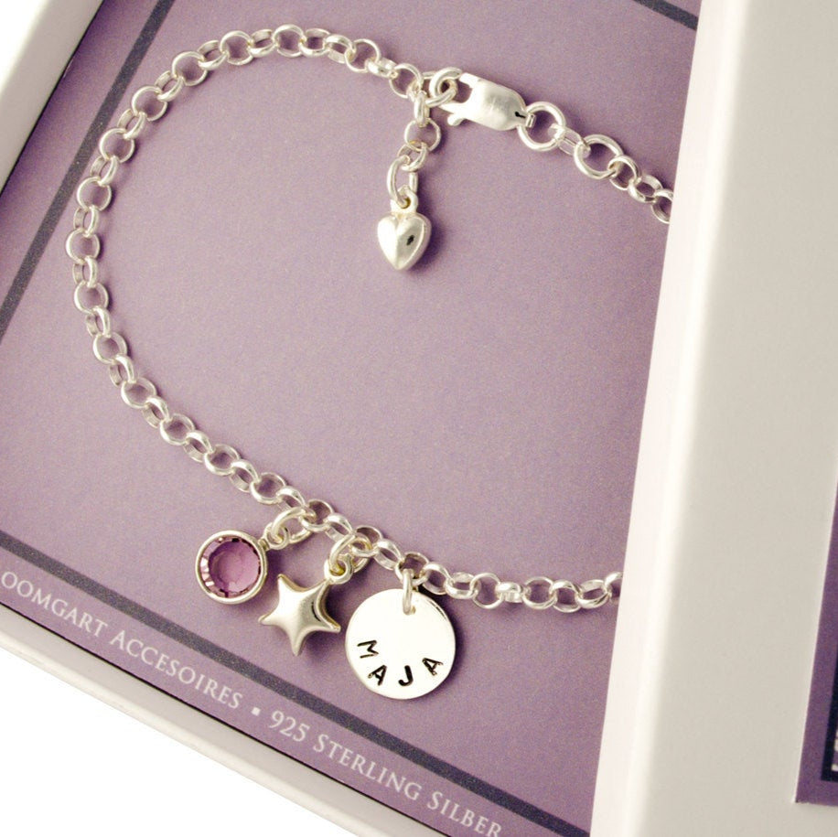 Gliederarmband mit Namenstaler, Glücksstern und Geburtsstein als glückbringendes Namensarmband in einer kleinen Geschenkbox präsentiert.