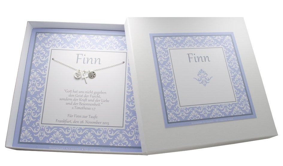 Gesamtansicht der Kette aus 925 Sliber mit Namensanhänger, Kreuz und Schutzengel im Taufring. Das Taufgeschenk für Jungen wird in einer  personalisierten Geschenkbox mit hellblauem Ornamentmuster präsentiert.