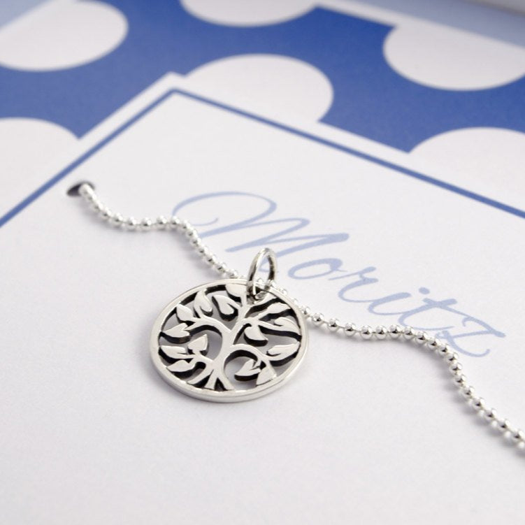 Lebensbaumschmuck für Jungen: an einer Sterling Silber Kugelkette ist ein filigran gearbeiteter Lebensbaum angebracht. Die Kette wird präsentiert in einer blau gepunkteten Geschenkbox, hier für 'Moritz'.