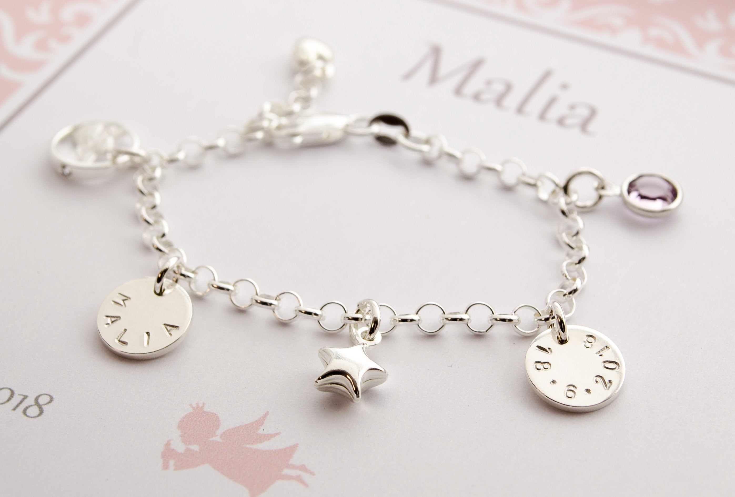 Bettelarmband zur Taufe mit handgestempelten Gravur-Anhängern mit Wunschgravur, Geburtsstein, Schutzengel in einer süßen rosa-weißen Geschenkbox, handgefertigt von Bloomgart.