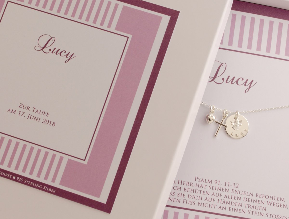 Detailansicht der Geschenkbox mit filigraner Silberkette mit Schutzengel, Kreuz und Herz-Anhänger, personalisiert für 'Lucy'. Unterhalb der Kette ist der Taufspruch: Psalm 91,11-12 gedruckt.